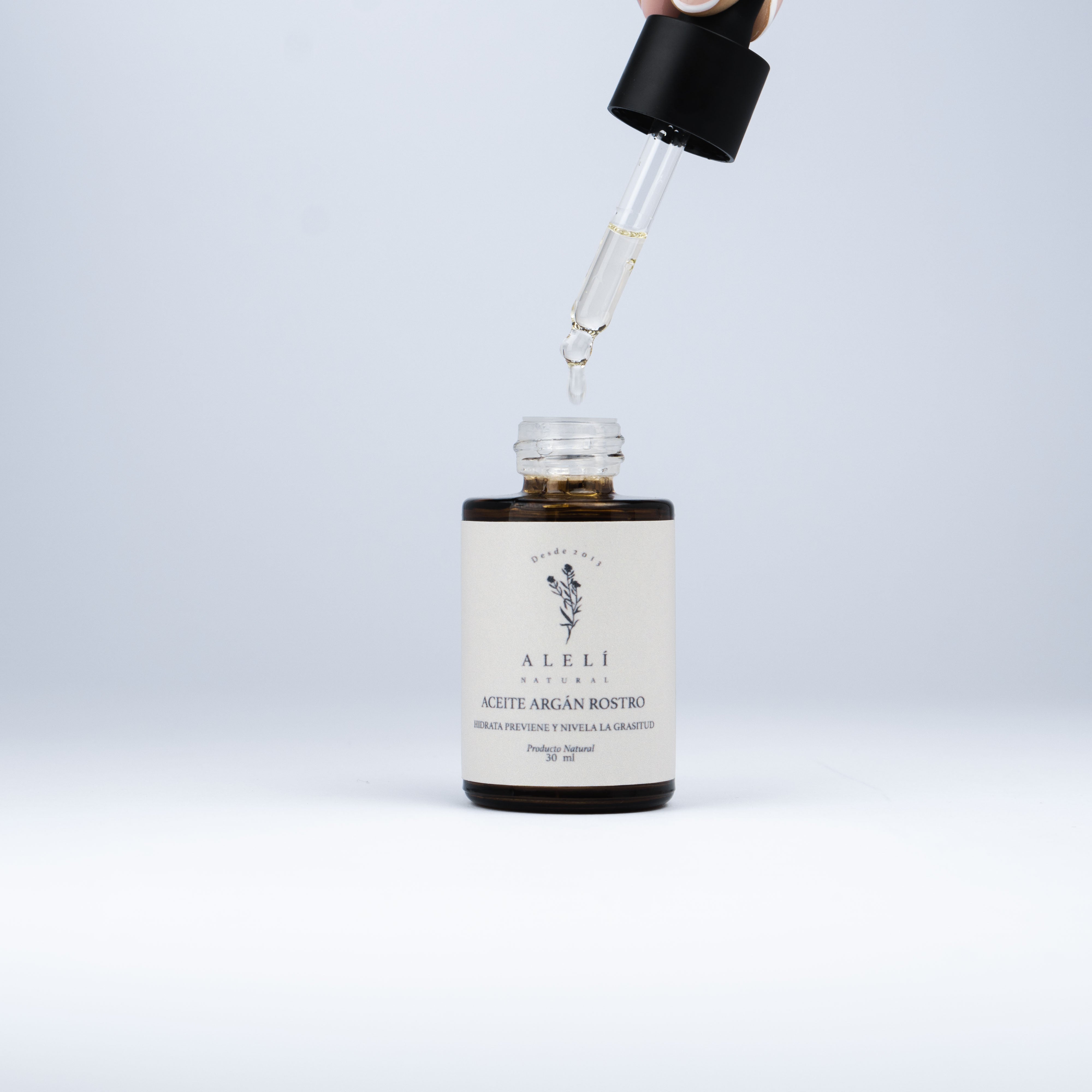 Aplicación del Aceite de Argán Alelí Natural. Gotero dispensando aceite desde el frasco.
