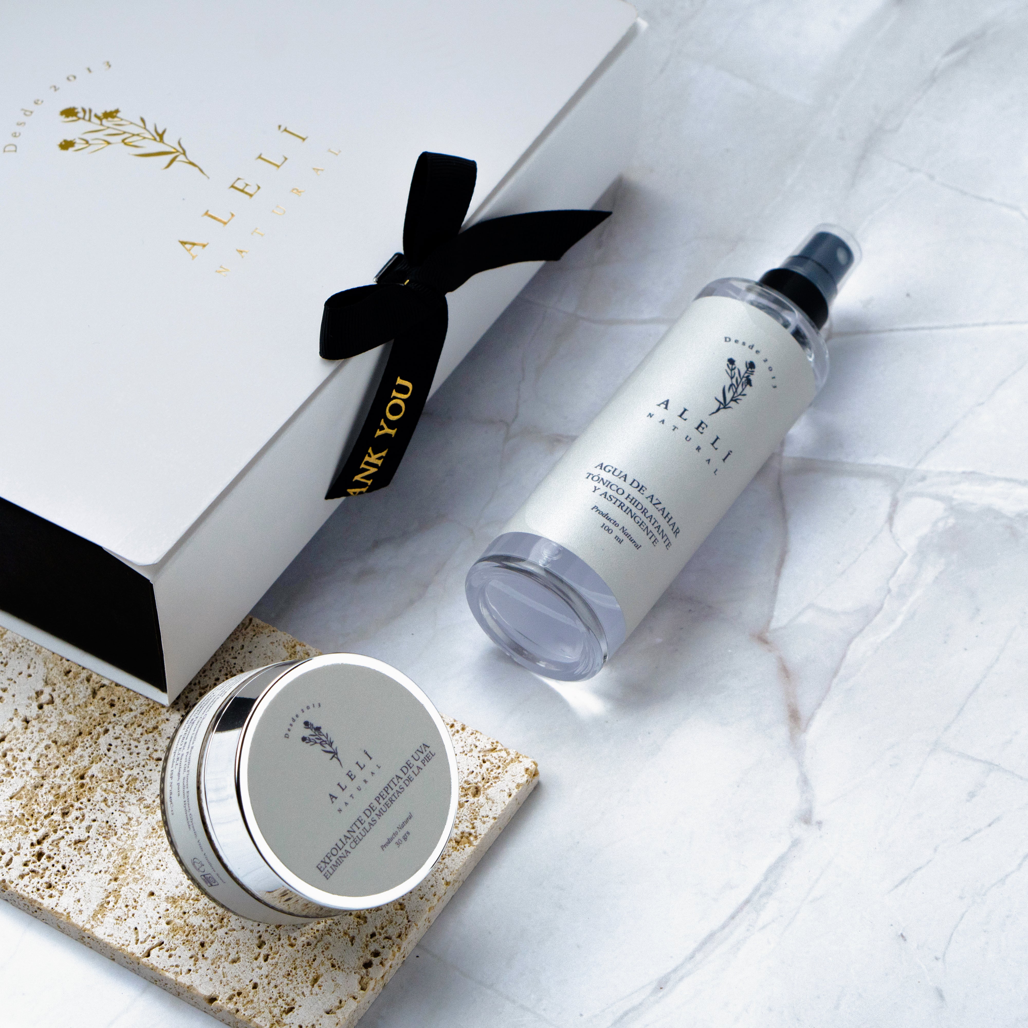 Vista frontal del Pack Momento Exfoliación Alelí Natural con exfoliante facial de pepita de uva y tónico oil control de agua de azahar.
